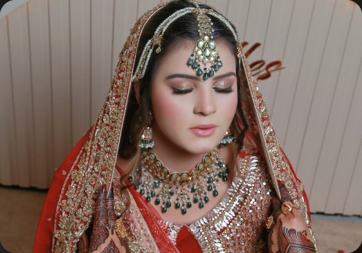 Bride in red dupatta with maang tikka and mehndi